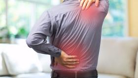 Man grabbing his back and shoulder