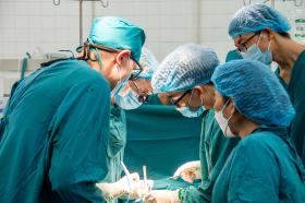 healthcare workers huddled around surgery patient healthcare workers huddled around surgery patient
