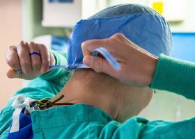 Nurse fixing scrub cap to head Nurse fixing scrub cap to head